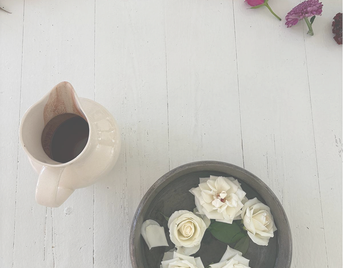 Blomster og keramikkande på et lyst træbord