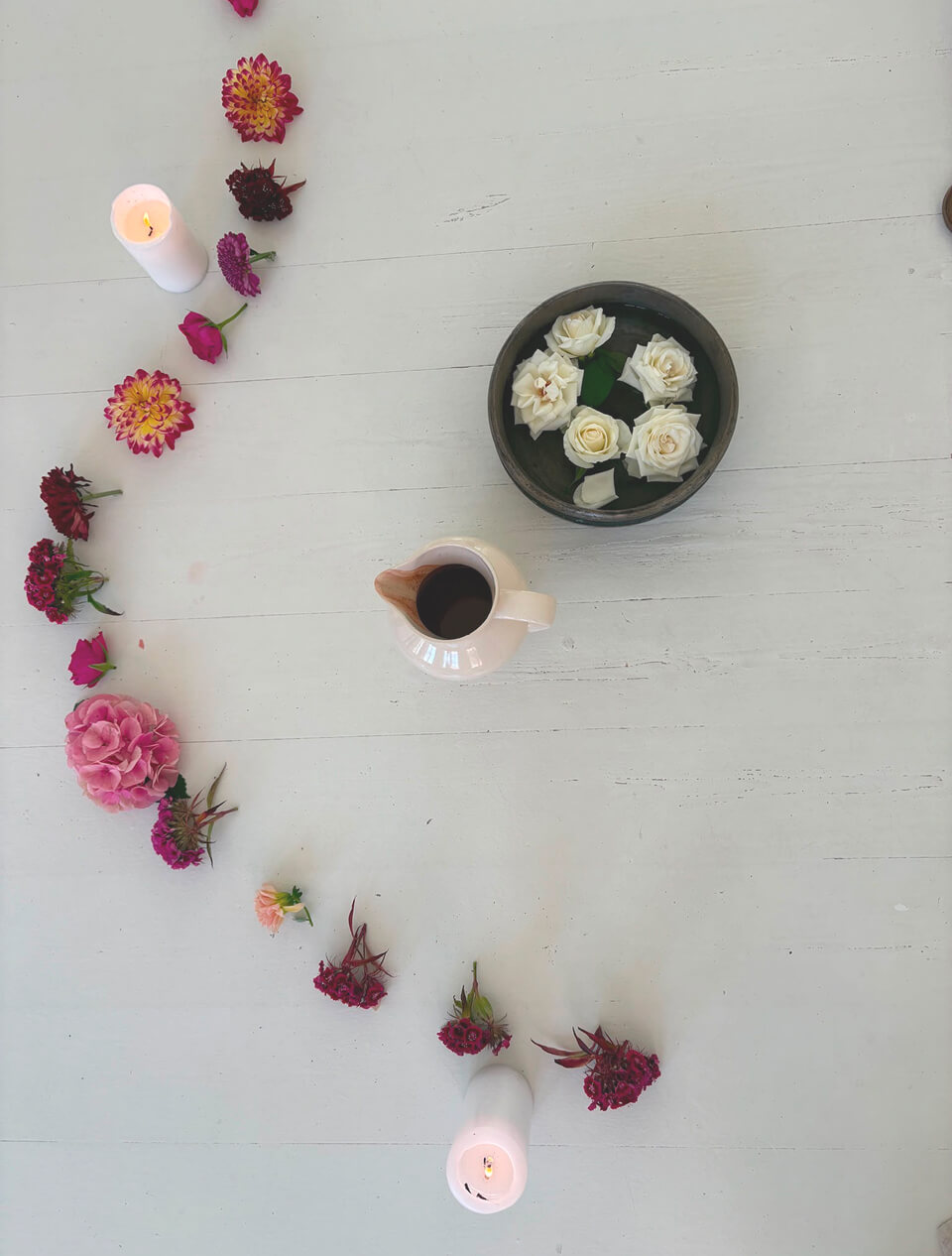 Flowers, candles and ceremonial cacao arranged in a circle